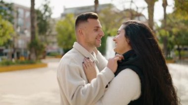 Young couple smiling confident hugging each other and kissing at park