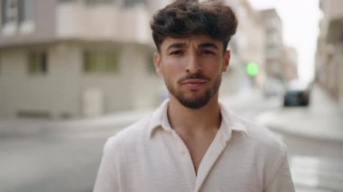 Young arab man smiling confident doing photo gesture with hands at street