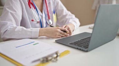 Genç, güzel İspanyol kadın doktor klinikte video görüşmesi yapıyor.