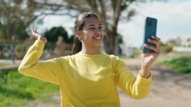 Genç Afro-Amerikan kadın gülümsüyor. Park 'ta video araması yaptığından emin.