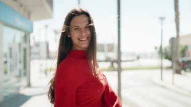Young woman smiling confident spinning on himself at street