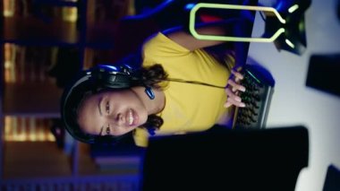 Young african american woman streamer playing video game using computer at gaming room