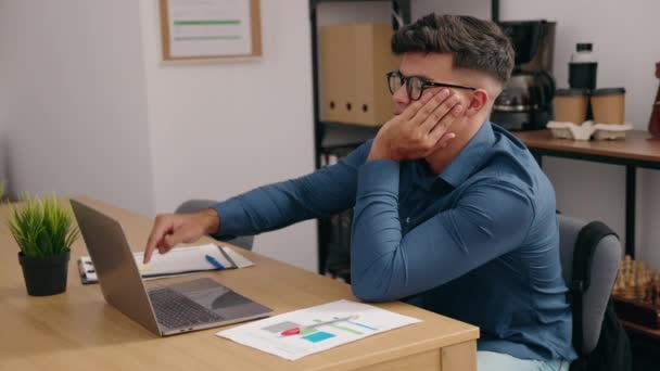 オフィスで退屈な式を持つラップトップを使用して若いヒスパニック系の男のビジネスワーカー — ストック動画