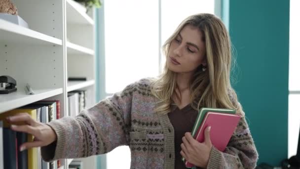 Young Blonde Woman Student Holding Books Doubt Expression Library University — Stok Video