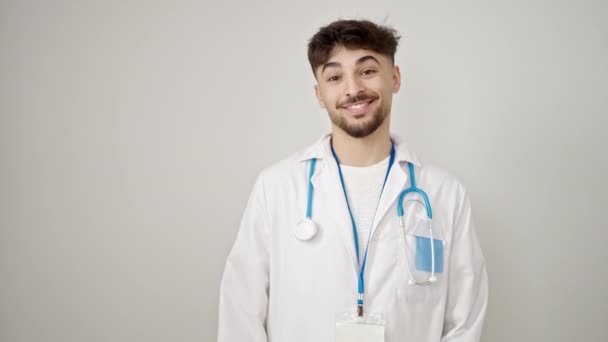 年轻的阿拉伯男子医生面带微笑 自信地把手指向一边 越过孤立的白色背景 — 图库视频影像