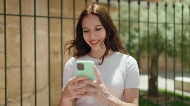 Junge Frau Lächelt Selbstbewusst Mit Smartphone Auf Der Straße — Stockvideo