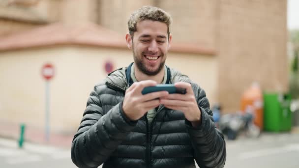 Молодий Чоловік Посміхається Впевнено Дивитися Відео Смартфон Вулиці — стокове відео
