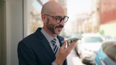 Young hispanic man executive smiling confident talking on smartphone at street