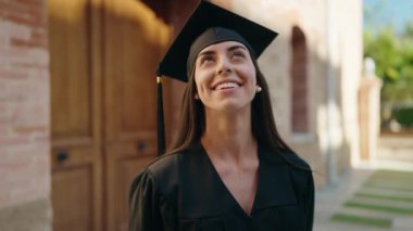 Üniversitede gökyüzüne bakan, üniformalı İspanyol bir kadın.