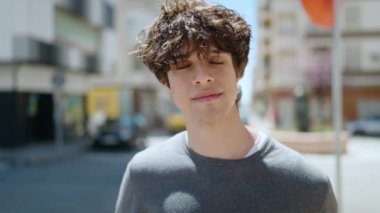 Sokakta müzik dinlerken kendinden emin gülümseyen İspanyol genç adam.
