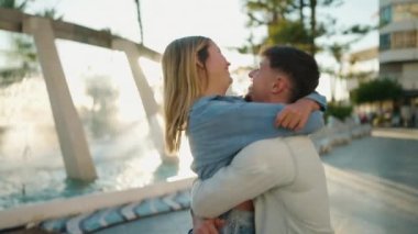 Young couple kissing and hugging each other standing at street