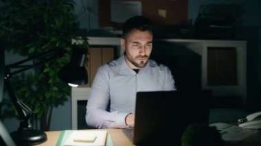 Young hispanic man business worker working overtime at office