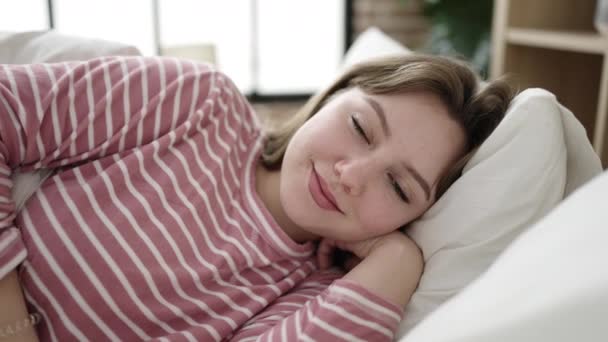 Junge Blonde Frau Lächelt Selbstbewusst Auf Bett Schlafzimmer Liegend — Stockvideo