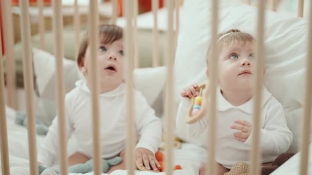 Två Bedårande Barn Suger Leksak Sitter Vaggan Sovrummet — Stockvideo