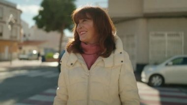 Middle age redhead woman smiling confident standing at street