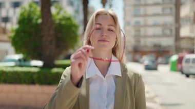 Young blonde woman executive smiling confident standing at park