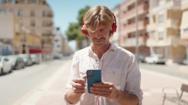 Genç adam kendine güvenen müzik dinleyen ve sokakta dans eden