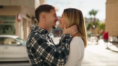 Young couple kissing and hugging each other standing at street