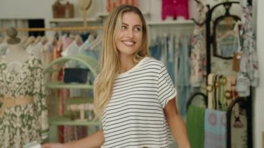 Alışveriş torbaları ve kredi kartı tutan genç sarışın kadın.