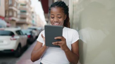 African american woman smiling confident using touchpad at street