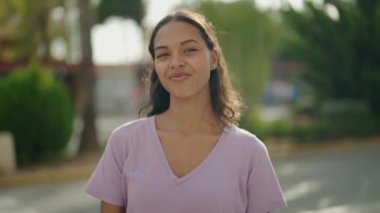Genç Afrikalı Amerikalı kadın gülümsüyor. Kendine güveni tam. Başparmağıyla sokakları imzalıyor.