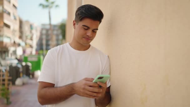 Jonge Spaanse Man Vieren Met Behulp Van Smartphone Straat — Stockvideo