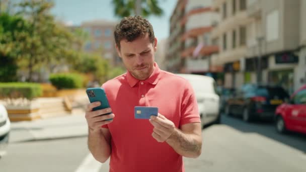 ストリートでスマートフォンやクレジットカードを使っている若いヒスパニック系の男 — ストック動画