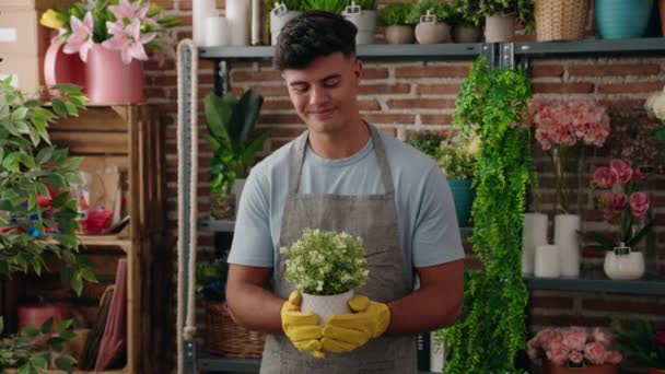 Νεαρός Ισπανός Ανθοπώλης Χαμογελά Αυτοπεποίθηση Μυρίζοντας Φυτό Στο Ανθοπωλείο — Αρχείο Βίντεο
