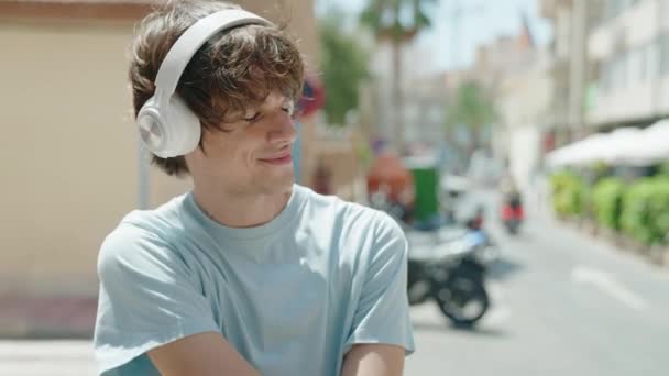 Νεαρός Ξανθός Άντρας Ακούει Μουσική Και Χορεύει Στο Δρόμο — Αρχείο Βίντεο