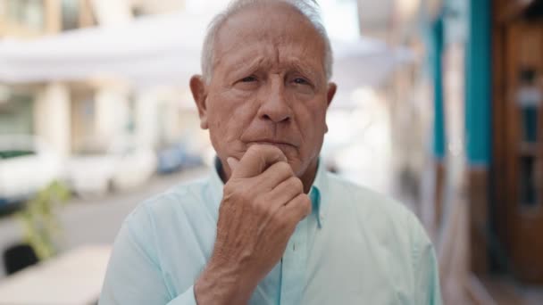 Yaşlı Gri Saçlı Adam Şüpheli Bir Ifadeyle Caddede Duruyor — Stok video