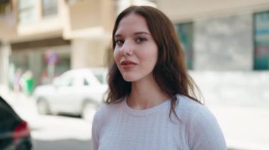 Sokakta kendinden emin gülümseyen genç bir kadın.