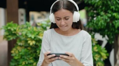 Genç, güzel İspanyol kadın gülümsüyor. Sokakta oyun oynarken kendine güveniyor.