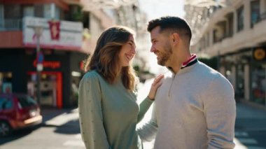 Young couple smiling confident hugging each other standing at street