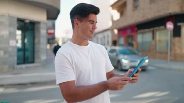 Latin asıllı genç adam gülümsüyor.