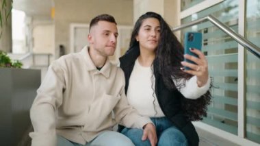 Young couple smiling confident making selfie by the smartphone at street