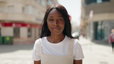 Young african american woman standing with celebration expression at street