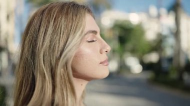 Sokakta kendine güvenen genç sarışın kadın gülümsüyor