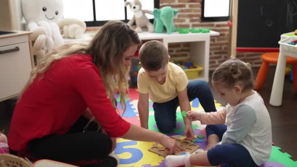 Lehrerin Mit Jungen Und Mädchen Beim Mathe Puzzlespiel Kindergarten — Stockvideo