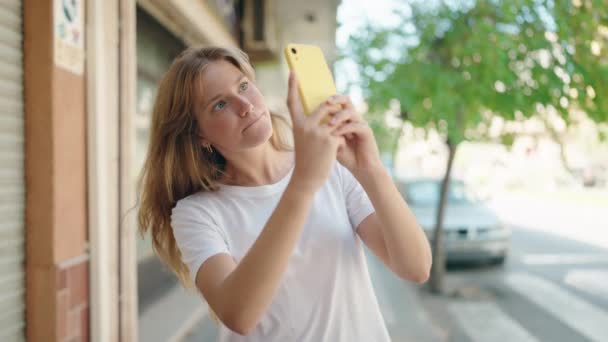 Jovem Loira Sorrindo Confiante Fazendo Foto Pelo Smartphone Rua — Vídeo de Stock