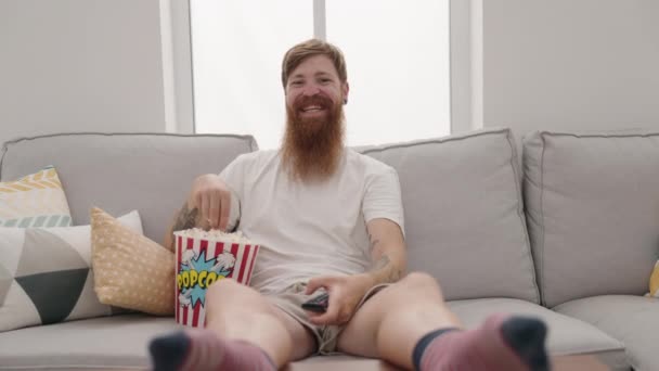 Young Redhead Man Watching Movie Sitting Sofa Home — Stock video