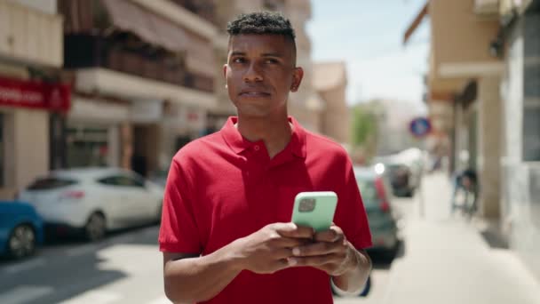 Young Latin Man Using Smartphone Serious Expression Street — Stock Video