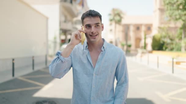 Νεαρός Ισπανός Άντρας Χαμογελάει Αυτοπεποίθηση Μιλώντας Στο Smartphone Περπατώντας Στο — Αρχείο Βίντεο