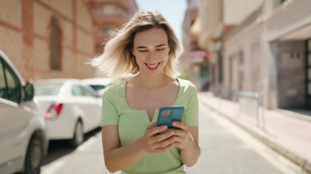 Jovem Sorrindo Confiante Usando Smartphone Andando Rua — Vídeo de Stock