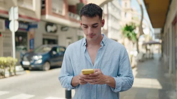 Joven Hispano Usando Smartphone Con Expresión Seria Calle — Vídeos de Stock