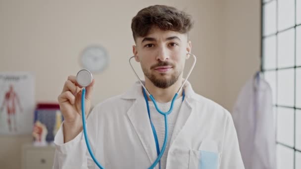 Молодий Арабський Лікар Посміхається Впевнено Тримає Стетоскоп Клініці — стокове відео