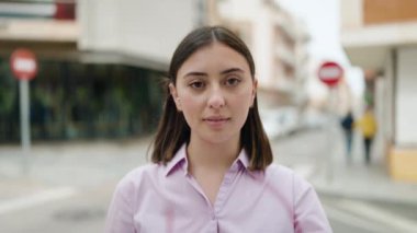 Young hispanic woman smiling confident wearing glasses at street