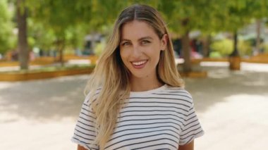 Young blonde woman smiling confident having video call at park