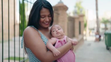 İspanyol ailesi gülümsüyor. Sokakta birbirlerine sarılıyorlar.