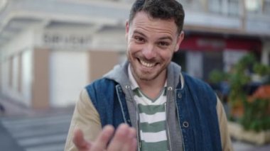 Beyaz bir adam gülümsüyor. Kendine güveniyor. Caddeye gelmek istiyor.