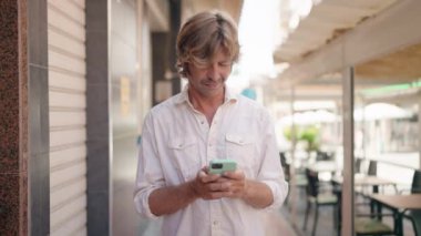 Young man using smartphone at street